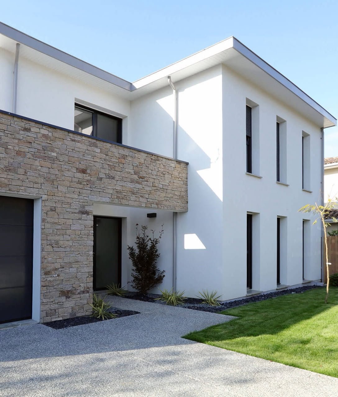 Façade de villa en enduit monocouche blanc jointoyée à un parement en pierre naturelle, réalisée par TOUITIGROUP